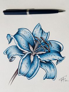 a drawing of a blue flower on white paper with a black pen next to it