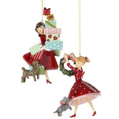 two christmas ornaments hanging from strings with a woman in red dress and dog on the other side