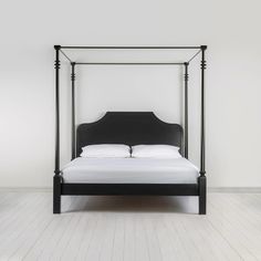 a black bed with white sheets and pillows