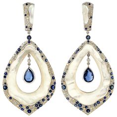 Cast from 18-karat gold, these stunning earrings are set with 4.0 carats of Kyanite, 23.92 carats mother of pearl and 2.61 carats of glimmering diamonds. FOLLOW MEGHNA JEWELS storefront to view the latest collection & exclusive pieces. Meghna Jewels is proudly rated as a Top Seller on 1stDibs with 5 star customer reviews. All items manufactured by us are handmade and can be customized or redesigned. Composition Size-75X34 Total Weight-24.82 Gold Weight(Gms)-18.092 Diamond Wt(Cts)-2.61 Kyanite Wt