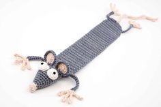 a crocheted mouse is laying down on the ground