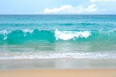 an ocean view with waves crashing on the beach