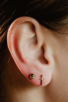 a close up of a person's ear with a cross and skull on it