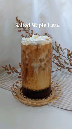 salted maple latte with whipped cream in a glass on a wicker plate