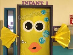 a yellow door decorated with paper flowers and an image of a monster's face