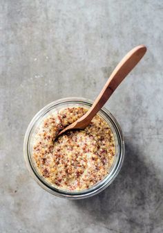 an overhead view of a jar filled with food and a wooden spoon on the side