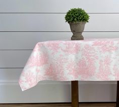 a potted plant sitting on top of a wooden table next to a white wall