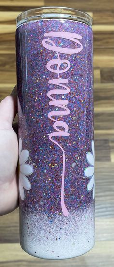 someone is holding up a purple and blue glittered tumbler with the word sparkle on it