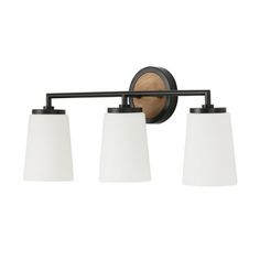 three light bathroom fixture in an old - fashioned style with white shades and black finish