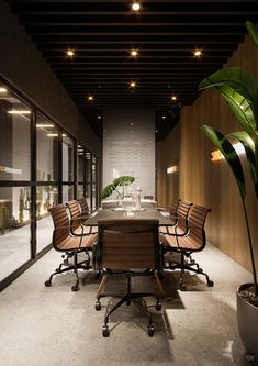 an empty conference room with several chairs and a table in the middle is lit by recessed lights