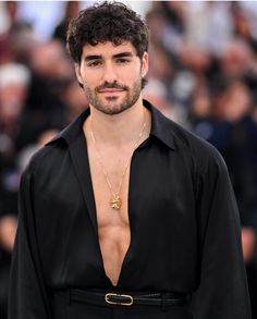 a man with no shirt standing in front of a crowd