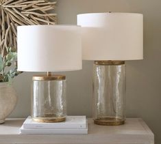 two glass jars sitting on top of a table next to a lamp