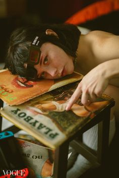 a woman laying on top of a table next to books