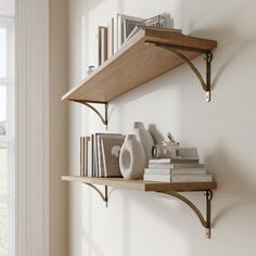 two wooden shelves with books and vases on them