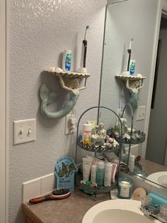 a bathroom sink with two toothbrush holders on the wall