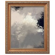 an ornate gold frame on a white wall with a black and grey painting in the background