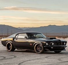 a black muscle car parked on top of a parking lot