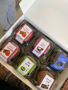 an open box filled with different types of food in it's display case on top of a table