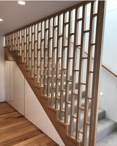 a wooden staircase with glass balconies and wood handrails in an empty room