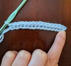 the crochet hook is being used to hold the yarn