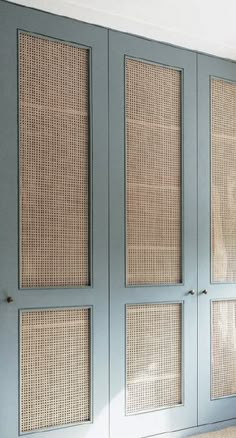 an empty room with blue doors and wicker panels