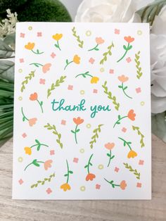 a thank card with flowers on it and the words thank you written in green ink