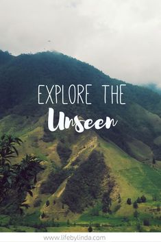 the words explore the unseen on top of a green mountain with mountains in the background