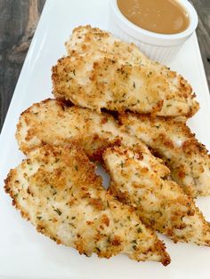 some fried food on a white plate with dipping sauce