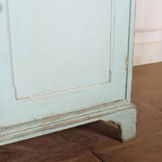 an old blue painted cabinet on the floor