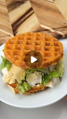 a waffle sandwich with lettuce and cheese on it sitting on a white plate