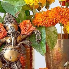 an elephant figurine sitting on top of a table next to flowers and vases