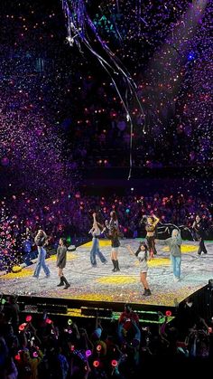 a group of people standing on top of a stage surrounded by confetti