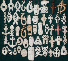 a collection of carved and carved items on a black surface, including cross, skull, head, eyes, nose, mouth