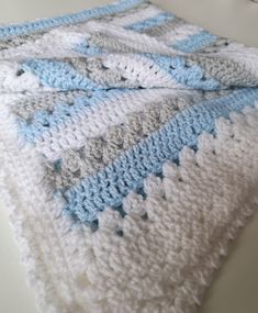 a crocheted blanket is laying on a table