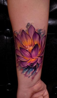 a woman's arm with a purple flower tattoo on the left side of her arm