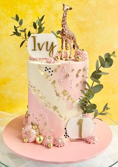 a pink and white cake with a giraffe on top