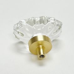 an image of a glass door handle on a white surface with gold trimmings