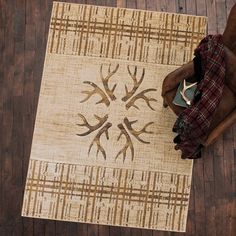 an overhead view of a rug with deer heads on it, sitting on a wooden floor