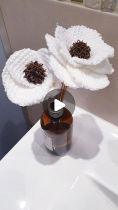 two white flowers are in a brown bottle