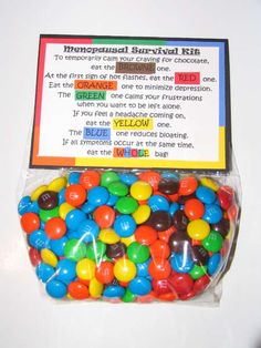 a bag filled with lots of colorful candies on top of a white table next to a sign