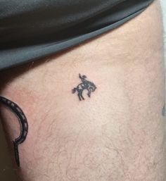 a man with a small tattoo on his leg that has a horse and rider on it