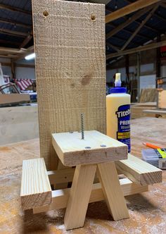 a piece of wood sitting on top of a table next to a bottle of glue