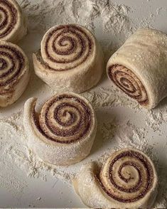 four cinnamon rolls sitting on top of a white counter