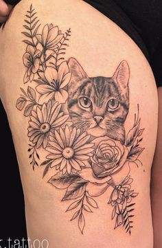 a woman's thigh with a cat and flowers on it