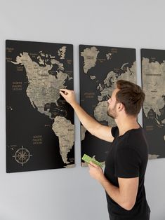 a man pointing to a world map on a wall