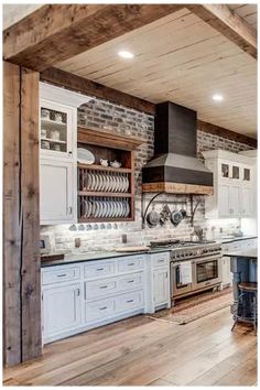 a large kitchen with white cabinets and wood flooring on the walls is pictured in this image