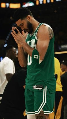 NBA basketball wallpaper background of Boston Celtics star Jason Tatum praying on the court Celtics Wallpaper