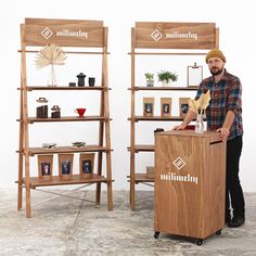 a man standing next to a wooden podium in front of shelves with pictures on them