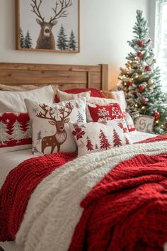 a bed covered in red and white pillows next to a christmas tree