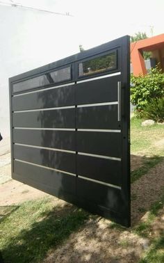 a large black garage door sitting in the grass